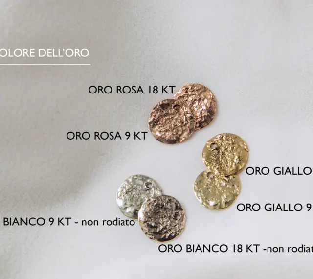 Monete in oro rosa, giallo e bianco, con texture martellata. L'oro rosso, in particolare, brilla con un calore unico.